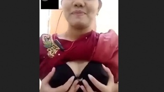 A stunning woman flaunts her large breasts and alluring pussy in a teasing display on camera