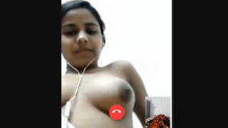 A college girl with perky breasts indulges in self-pleasure during a video call