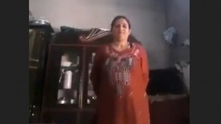 A Pakistani woman removes her clothing to unveil her large breasts and genitalia